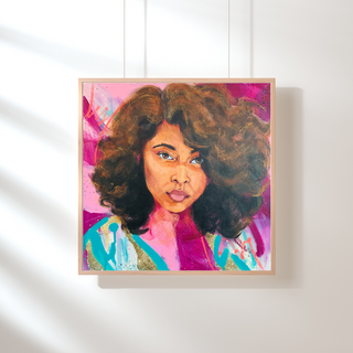 Framed artwork of a woman with curly hair on a white wall