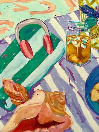 Colorful painting of a beach scene with seashells, a glass of iced tea, and headphone on a striped towel and beach blanket.